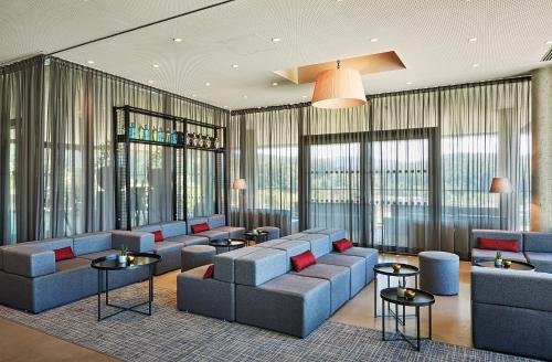 a lobby with couches and tables and windows at LOISIUM Wine & Spa Hotel Südsteiermark in Ehrenhausen