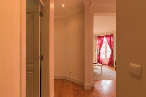 un couloir vide avec une porte menant au salon dans l'établissement "HomeySuite" in Lisbon City Centre, à Lisbonne