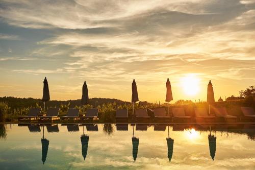 a group of chairs sitting next to a swimming pool at LOISIUM Wine & Spa Hotel Südsteiermark in Ehrenhausen