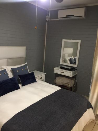 a bedroom with a bed and a mirror at DeTlous BnB in Empangeni