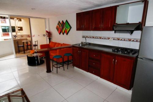 a kitchen with red cabinets and a table and chairs at El Velero Apartamentos By DANP in Santa Marta
