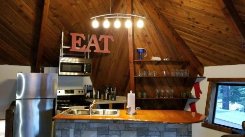 una cocina con una barra con un cartel de comida en la pared en Tree House- Walk to Mammoth Village en Mammoth Lakes