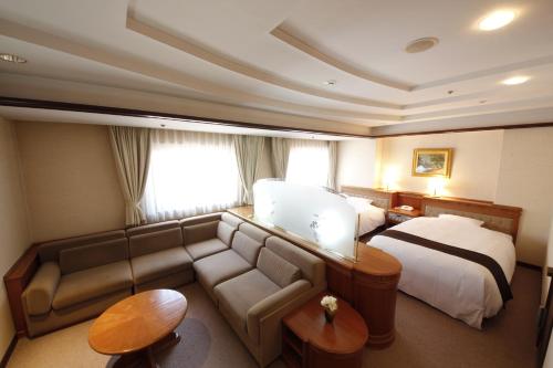 a hotel room with a couch and a bed at Hotel Hiroshima Garden Palace in Hiroshima