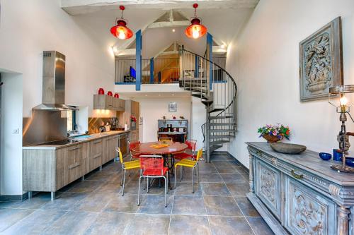 une cuisine avec une table et des chaises et un escalier en colimaçon dans l'établissement Le Domaine du Douet du Houle, Piscine & SPA, 2-19p, à Courcy