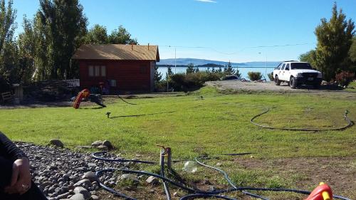 a man is working in a yard next to a house at Cabañas Oyikil in El Calafate