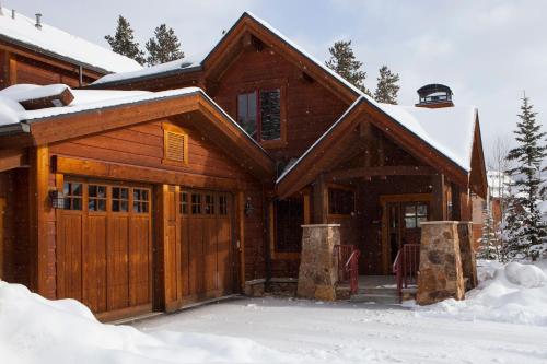 a wooden house with a garage in the snow at Mountain Thunder Lodge in Breckenridge