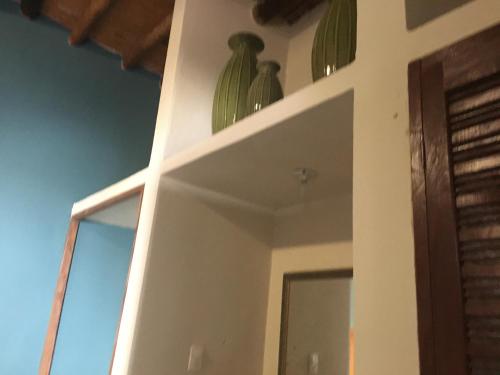 a shelf with two green vases on top of it at Hostal Doña Carlota Hotel in Cuatrociénegas de Carranza
