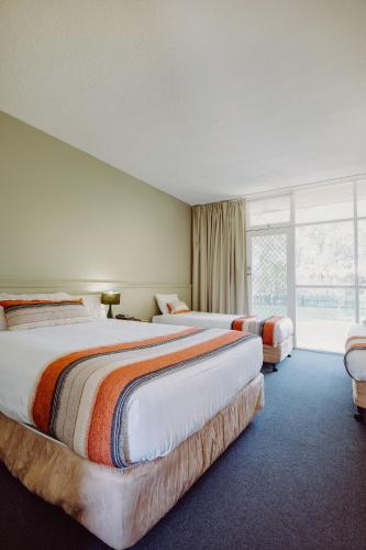 a hotel room with two beds and a window at Artesian Spa Motel in Moree