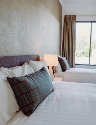 a hotel room with two beds and a couch at Artesian Spa Motel in Moree