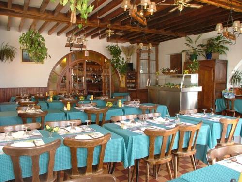 a large dining room with blue tables and chairs at Hôtel de la Place in Germigny-des-Prés