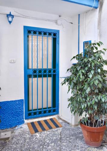 niebieskie drzwi w białym budynku z doniczką w obiekcie Secret Room Naples w mieście Neapol