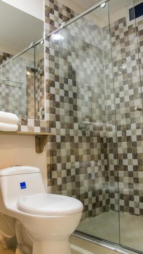 a bathroom with a toilet and a glass shower at Hotel Viña Del Mar in Santa Marta
