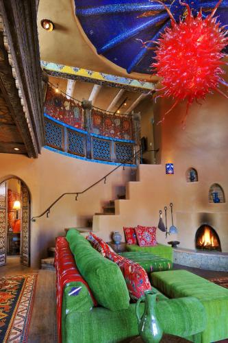 a living room with green couches and a fire place at The Inn of Five Graces in Santa Fe