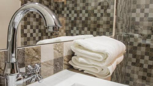 une pile de serviettes assises sur un comptoir à côté d'un lavabo dans l'établissement Hotel Viña Del Mar, à Santa Marta