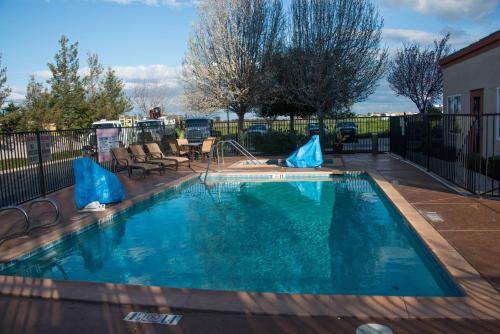 a swimming pool with blue water in a yard at Best Western Plus Delta Inn & Suites in Oakley