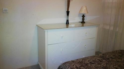 a white dresser with a lamp on top of it at 1002 Crystal Court Condominiums in Saint James