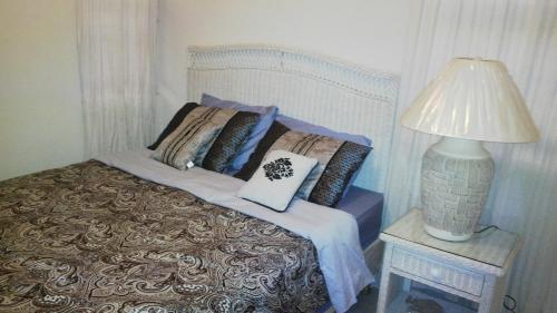 una cama con almohadas y una lámpara en una mesa en 1002 Crystal Court Condominiums en Saint James