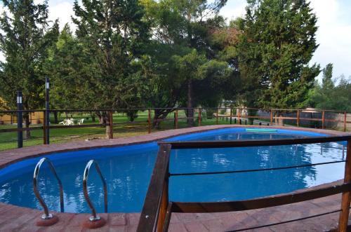 a swimming pool with a wooden fence around it at Posada del Viajero San Rafael in San Rafael