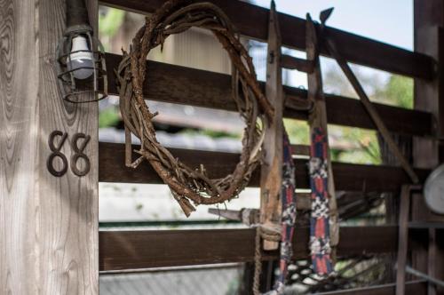 a wreath on the side of a wooden door with scissors at 88 House Hiroshima in Hiroshima