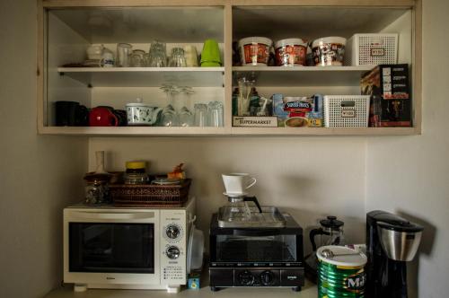a kitchen with a microwave and a toaster oven at 88 House Hiroshima in Hiroshima