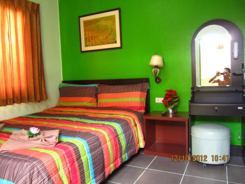 a bedroom with a bed and a green wall at Popeye Guesthouse in Ao Nang Beach