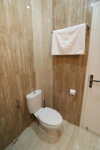 a bathroom with a toilet and a towel on the wall at Diyar Villas Puncak K3/2A in Puncak