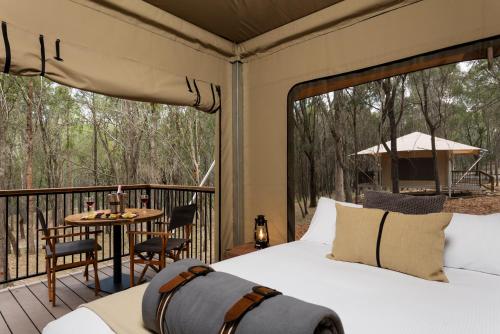 a bedroom with a bed and a balcony with a table at Paradise Country Farmstay in Gold Coast