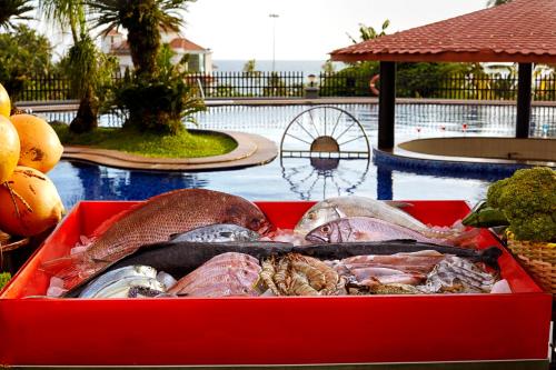 a red box filled with different types of fish next to a pool at Gateway Varkala in Varkala