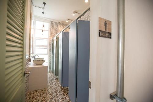 a hallway with a bathroom with a toilet and a sink at Memmoth Hostel In Lampang in Lampang
