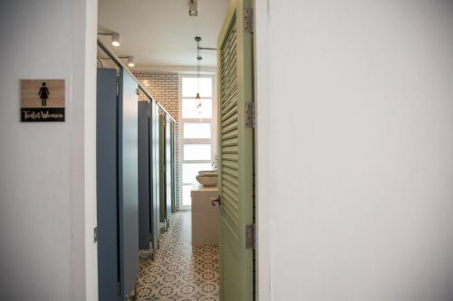 a hallway with green and blue doors and a tile floor at Memmoth Hostel In Lampang in Lampang