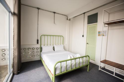 a bedroom with a bed with a green frame at Memmoth Hostel In Lampang in Lampang