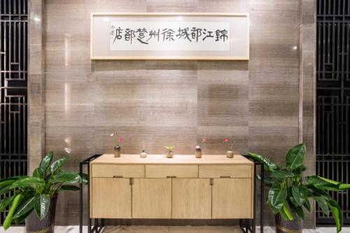 a bathroom with a sink and two plants at Metropolo Jinjiang Xuzhou Railway Station Suning Plaza Chudu in Xuzhou