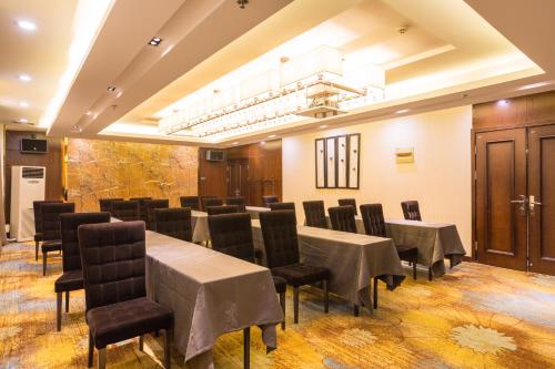 a conference room with tables and chairs and a chandelier at Metropolo Jinjiang Xuzhou Railway Station Suning Plaza Chudu in Xuzhou