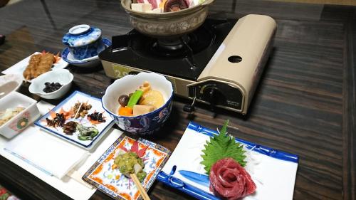 una mesa con un plato de comida y una licuadora en Minshuku Yurika, en Urugi