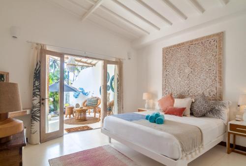 龍目島的住宿－De'Coco Villa，一间卧室设有一张床,并有通往庭院的门