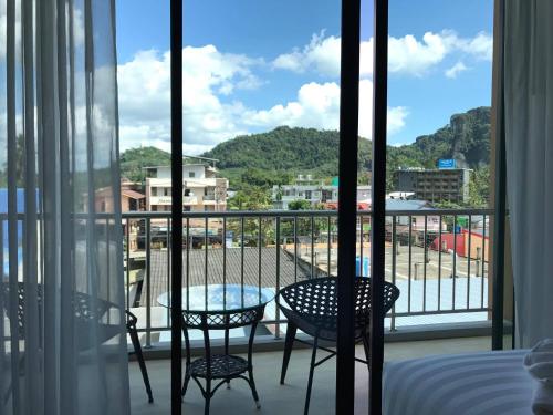 a balcony with two chairs and a view of a city at Aonang Sea Valley Resort in Ao Nang Beach