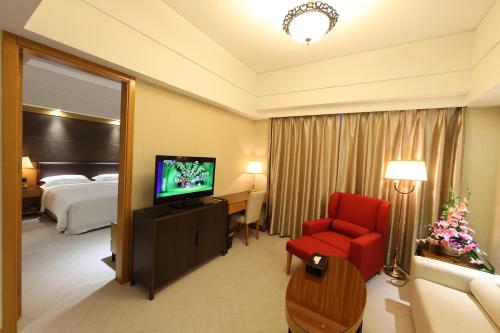 a hotel room with a bed and a television at Aurum International Hotel Xi'an in Xi'an