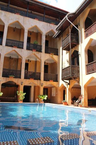 a hotel with a swimming pool in front of a building at Mizingani Seafront Hotel in Zanzibar City