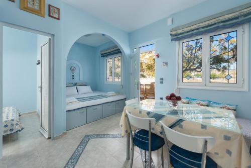 a blue kitchen with a table and a sink at Stella Beach House in Archangelos