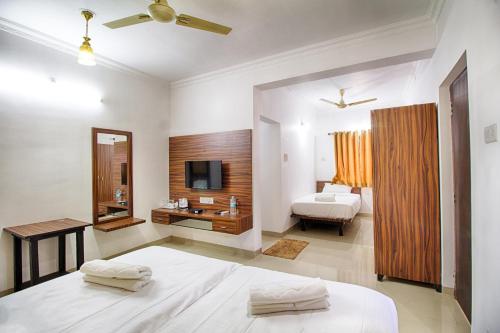 a bedroom with a bed and a bathroom with a television at Iora Baga Beach in Baga