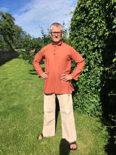 a man standing in the grass in a yard at Vila Migla in Pašekščiai