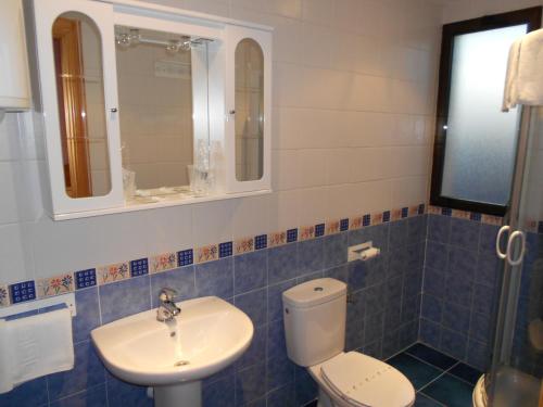 a bathroom with a toilet and a sink at Hostal Donaire in Tomelloso