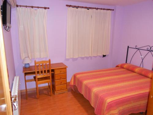 トメリョソにあるHostal Donaireのベッドルーム1室(ベッド1台、デスク、椅子付)