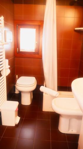 a bathroom with two toilets and a sink and a window at hotel Vajont in Vaiont