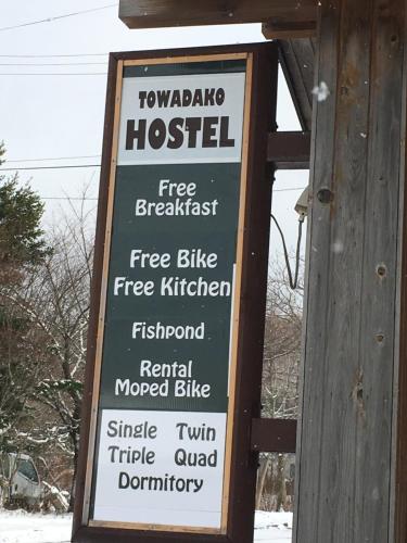 a sign on a wooden building that says topazino hospital at Towadako Hostel in Towada