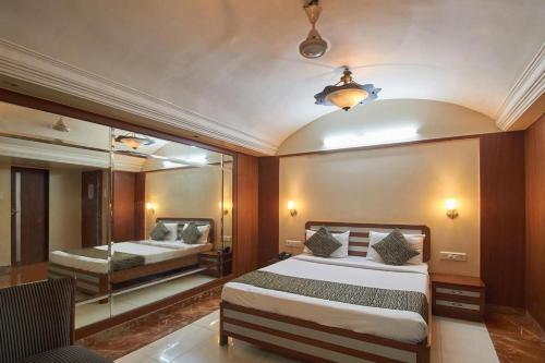 a bedroom with two beds and a mirror at Yogi Broadway in Mumbai