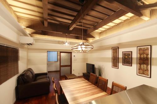 - une salle à manger et un salon avec une table en bois dans l'établissement Chikyuutabikazoku USJ, à Osaka