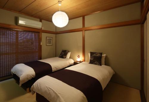 een kamer met twee bedden in een kamer bij Chikyuutabikazoku USJ in Osaka