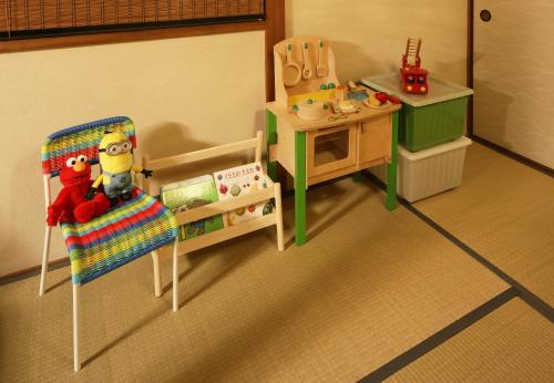 a toy room with a crib and a chair and a table at Chikyuutabikazoku USJ in Osaka