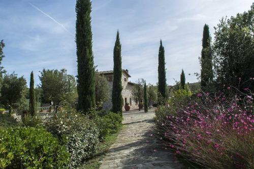 a garden with trees and a building in the background at Agriturismo Le Gallozzole in Monteriggioni
